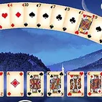 Karte za poker raspoređene u obliku luka iznad zimskog pejzaža sa planinama