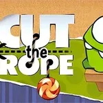 Zeleni lik Om Nom iz igre Cut the Rope sa bombonom na konopcu